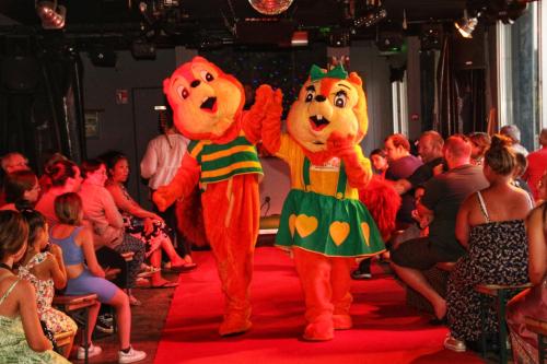 deux mascottes marchant sur une piste devant une foule dans l'établissement Camping Monaco Parc, à La Porte