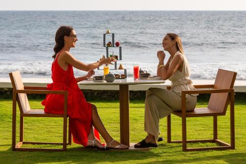 two women sitting at a table in front of the ocean at Radisson Collection Resort Galle in Galle