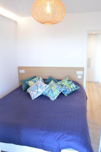- un lit avec des draps et des oreillers bleus dans une chambre dans l'établissement Appartement 2P vue mer Antibes, à Antibes