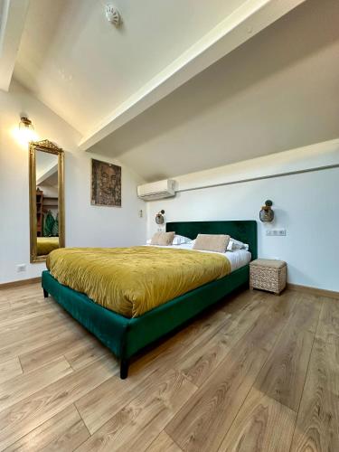a bedroom with a large bed with a green headboard at Hôtel Eden Cassis - centre-ville- piscine chauffée, jacuzzi et sauna - parking privé in Cassis