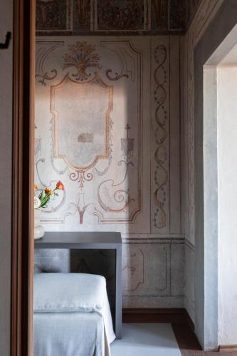 a bedroom with a wall with a mirror and two beds at Collegio alla Querce, Auberge Collection in Florence
