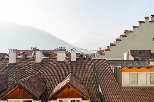 a view of roofs of buildings with mountains in the background at Artist House in Merano