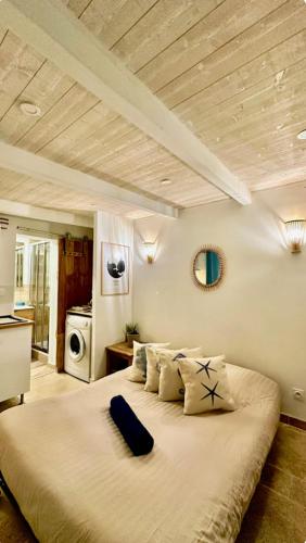 une chambre avec un grand lit dans une pièce dans l'établissement Le cocon de Charlotte, à Hyères