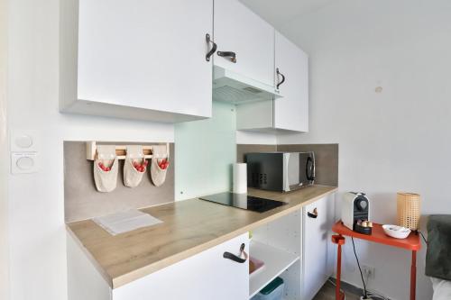 une cuisine avec des placards blancs et un comptoir dans l'établissement Studio with a 20sqm terrace 10min from la Croisette, à Cannes