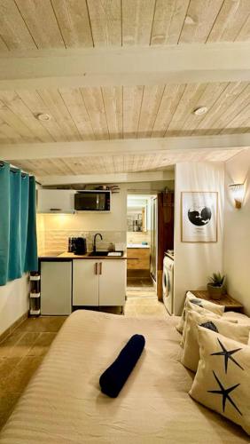 une chambre avec un grand lit et une cuisine dans l'établissement Le cocon de Charlotte, à Hyères