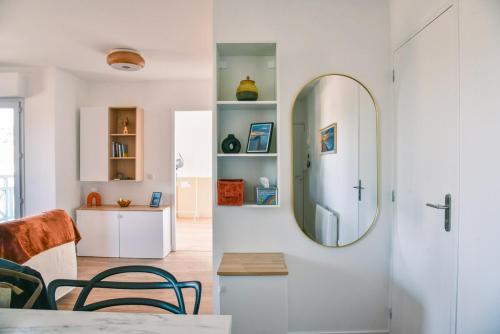 Una sala de estar con un espejo y una mesa. en L'Azalée, city center apartment, en Capbreton