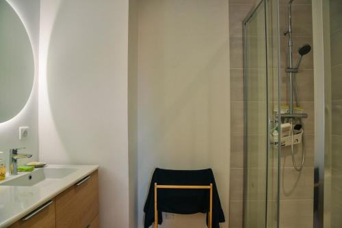 y baño con ducha, lavabo y silla. en L'Azalée, city center apartment, en Capbreton
