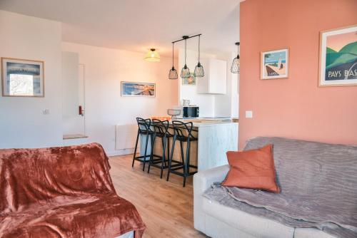 un salon avec un canapé et une cuisine dans l'établissement L'Azalée, city center apartment, à Capbreton