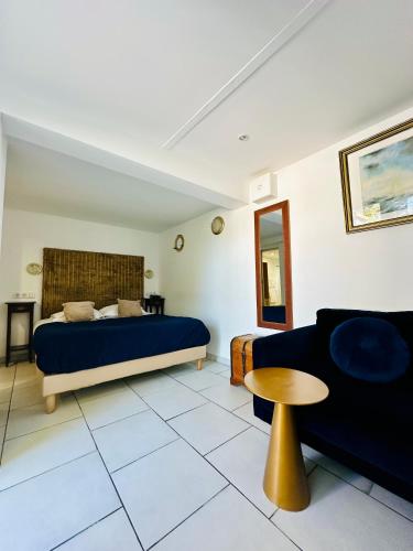 a bedroom with a blue bed and a couch at Hôtel Eden Cassis - centre-ville- piscine chauffée, jacuzzi et sauna - parking privé in Cassis