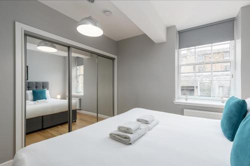 a white bedroom with a bed and a window at Destiny Scotland Apartments at Canning Street Lane in Edinburgh