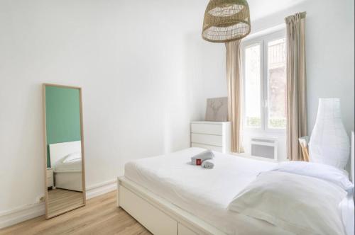 - une chambre blanche avec un miroir et un lit dans l'établissement 78GOUF - Appartement confortable au coeur de la ville, à Marseille