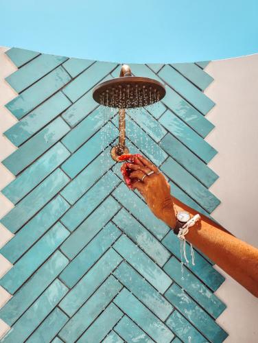 a person is washing a wall with a shower at Yzerfontein Villa Fantastica - No Loadshedding in Yzerfontein