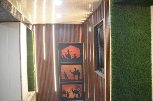 a wall with paintings of people and horses on it at ViratHomestay in Varanasi