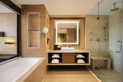 a bathroom with a tub and a sink and a shower at Courtyard by Marriott Bhopal in Bhopal