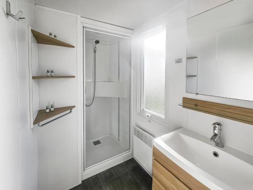 ein weißes Badezimmer mit Dusche und Waschbecken in der Unterkunft Mobile Home Luca - Séjour Nature in Litteau