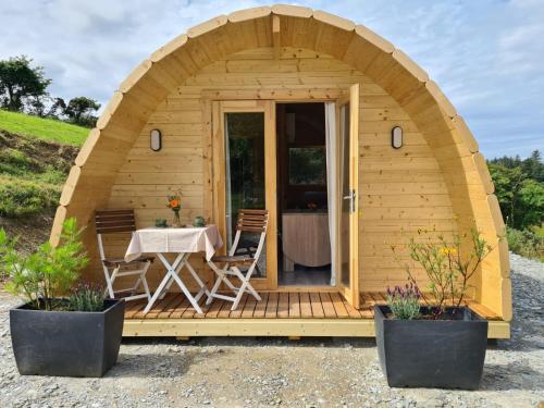 a small wooden cabin with a table and chairs in it at Gouladoo Retreat in Bantry