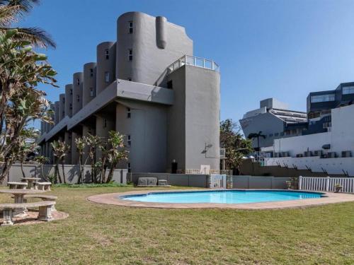a building with a swimming pool in front of a building at Idwala Tides 14 Casablanca Tri-Story Apartment - Ballito in Ballito
