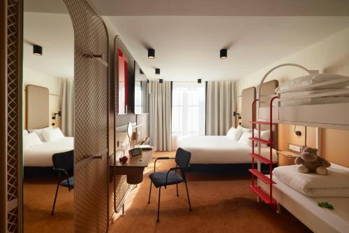 a hotel room with two bunk beds and a desk at YOU Are Deauville in Deauville
