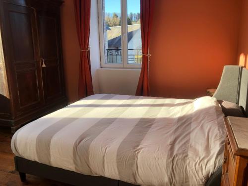 a bedroom with a bed and a window at L'hôte des voyageurs en pays Limousin 3 in Lacelle