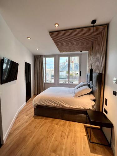 une chambre avec un grand lit et une grande fenêtre dans l'établissement Spacious newly renovated loft with AC, à Paris