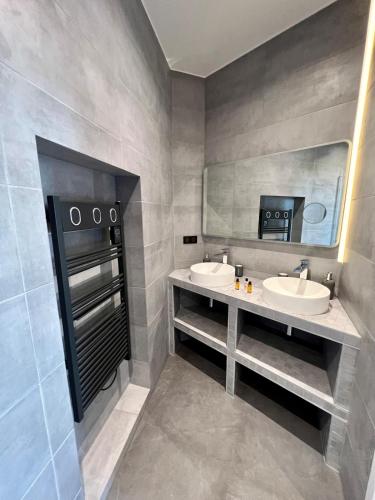 une salle de bain avec deux lavabos et un miroir dans l'établissement Spacious newly renovated loft with AC, à Paris
