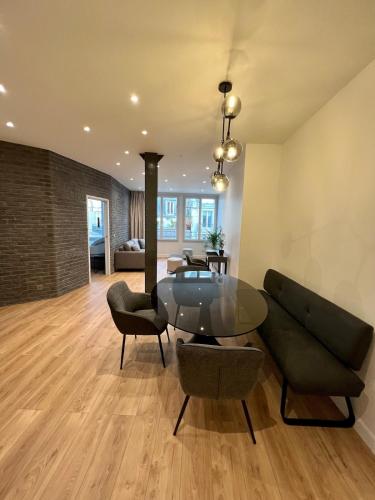 un salon avec une table en verre et des chaises dans l'établissement Spacious newly renovated loft with AC, à Paris