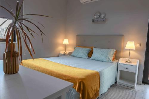 um quarto com uma cama e um vaso de plantas em Agua Viva by Umbral em Albufeira