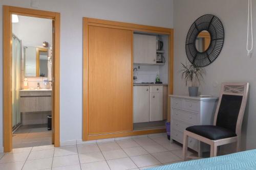 uma cozinha com uma porta de madeira e uma cadeira num quarto em Agua Viva by Umbral em Albufeira