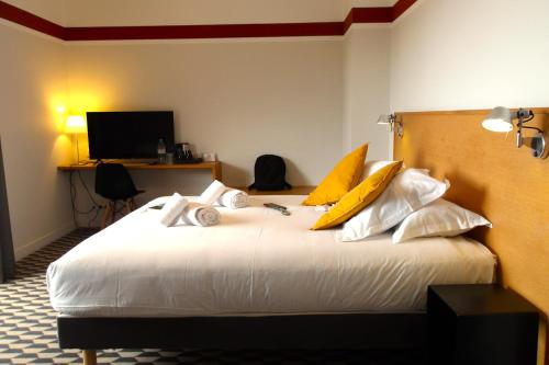 a bedroom with a large white bed with yellow pillows at La Maison des Ocres - Provence in Roussillon