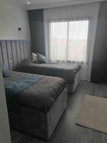 a bedroom with two beds and a window at Marrakech River Palm in Dar Caïd Layadi