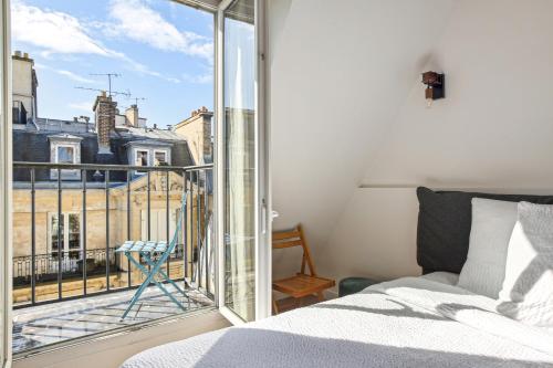 une chambre avec un lit et une grande fenêtre dans l'établissement Cosy apartment - 4P 1BR - Porte-Dauphine-Trocadero, à Paris