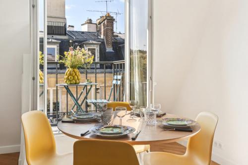 une salle à manger avec une table et des chaises et une grande fenêtre dans l'établissement Cosy apartment - 4P 1BR - Porte-Dauphine-Trocadero, à Paris