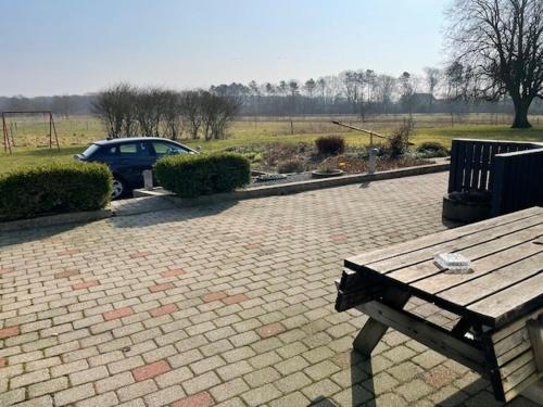a wooden bench sitting on top of a brick patio at Marskferie Tønder in Tønder