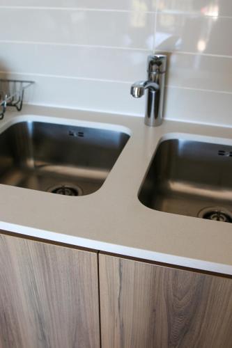a kitchen counter with a sink in a kitchen at The Jade Somerset West Beachfront Apartment with Pool & Mountain Views in Cape Town