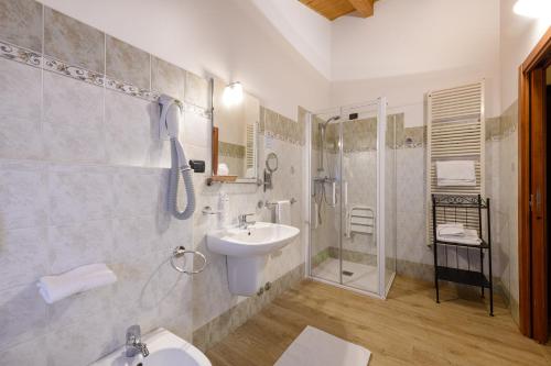 a bathroom with a sink and a toilet and a shower at Hotel Garni Le Corti in Grosotto