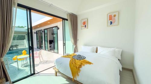 a bedroom with a bed and a balcony at Wana Villa ChaAM in Cha Am