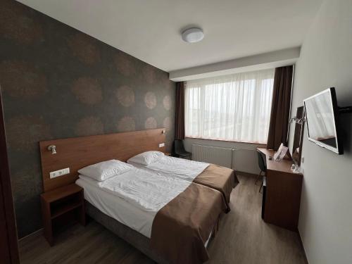 Una habitación de hotel con una cama y una ventana. en Benczur Hotel, en Budapest