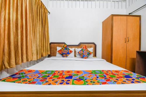 a bedroom with a bed with a colorful comforter at FabExpress Astoria House - Near Central Park in kolkata