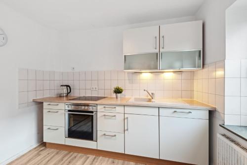 a kitchen with white cabinets and a sink at Worker Apartment Goch in Goch
