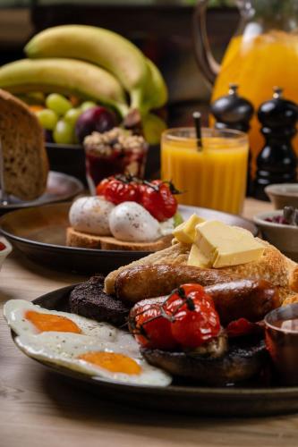 - une table avec deux assiettes de produits pour le petit-déjeuner et des fruits dans l'établissement The Winning Post, à Windsor