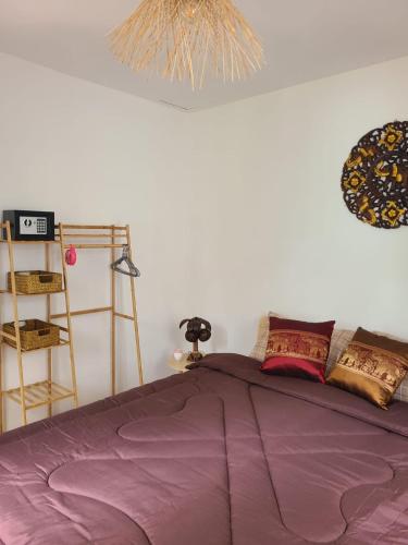 a bed with a purple comforter in a bedroom at Leelawadee Bungalow and Restaurant in Mae Nam