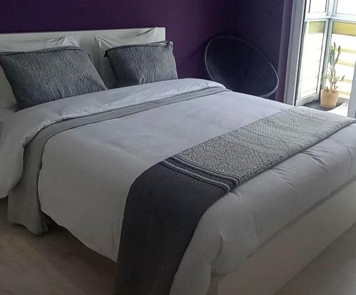 a bedroom with a large white bed with pillows at Vista para a serra in Bragança