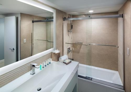 ジョージ・タウンにあるザ ウェスティン グランド ケイマン セブン マイル ビーチ リゾート & スパのシャワーと白い洗面台を備えたバスルーム