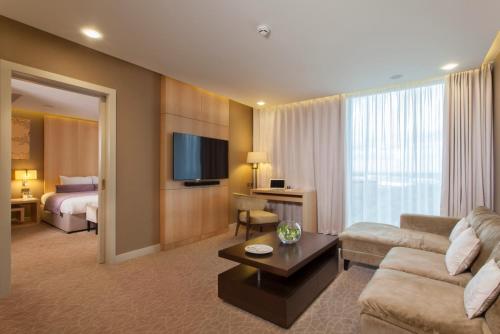 a living room with a couch and a room with a bed at Genting Hotel & Spa at Resorts World Birmingham in Bickenhill