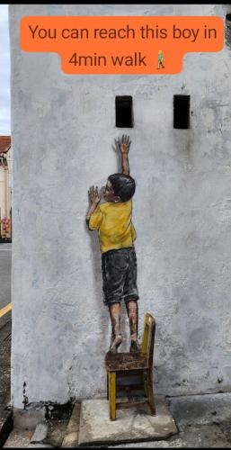a painting of a young boy on a wall at Hotel Lang Hoose in George Town