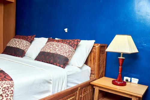 a bedroom with a bed with a blue wall at CONGRESS HOTEL Yaoundé in Yaoundé