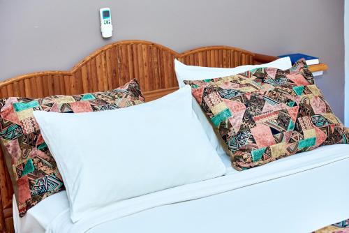 a bed with white sheets and pillows on it at CONGRESS HOTEL Yaoundé in Yaoundé