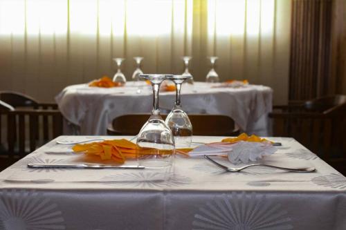 a table with a white table cloth with wine glasses on it at CONGRESS HOTEL Yaoundé in Yaoundé