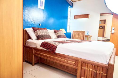 a bedroom with a bed with a blue wall at CONGRESS HOTEL Yaoundé in Yaoundé