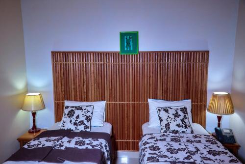 a hotel room with two beds and a green sign above them at CONGRESS HOTEL Yaoundé in Yaoundé